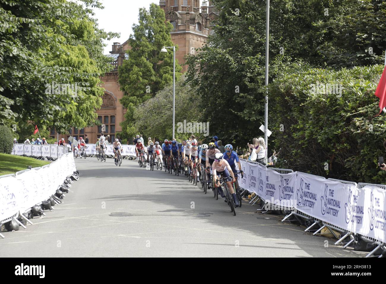 Il peloton che attraversa il Kelvingrove Park durante un giro in città della UCI Cycling World Championships Women Elite Road Race. Kelvingrove Museum and Art Gallery è sullo sfondo. Glasgow, Scozia, Regno Unito. 13 agosto 2023. Crediti: Elizabeth Leyden/Alamy Live News Foto Stock