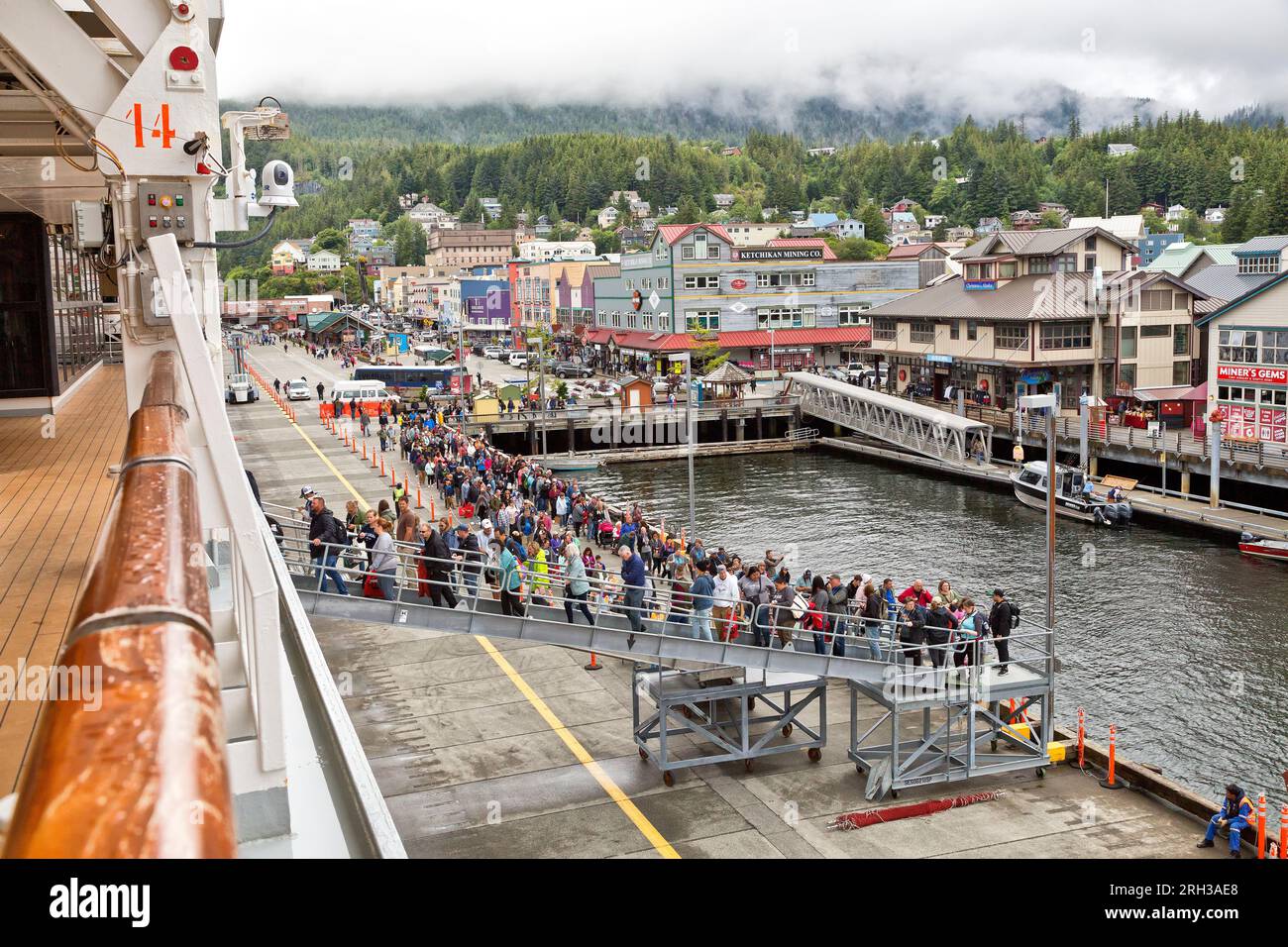 I passeggeri che ritornano da escursioni a terra e shopping alla nave da crociera Carnival luminosa, nebbia intrusiva, porto di Ketchikan, Alaska. Foto Stock