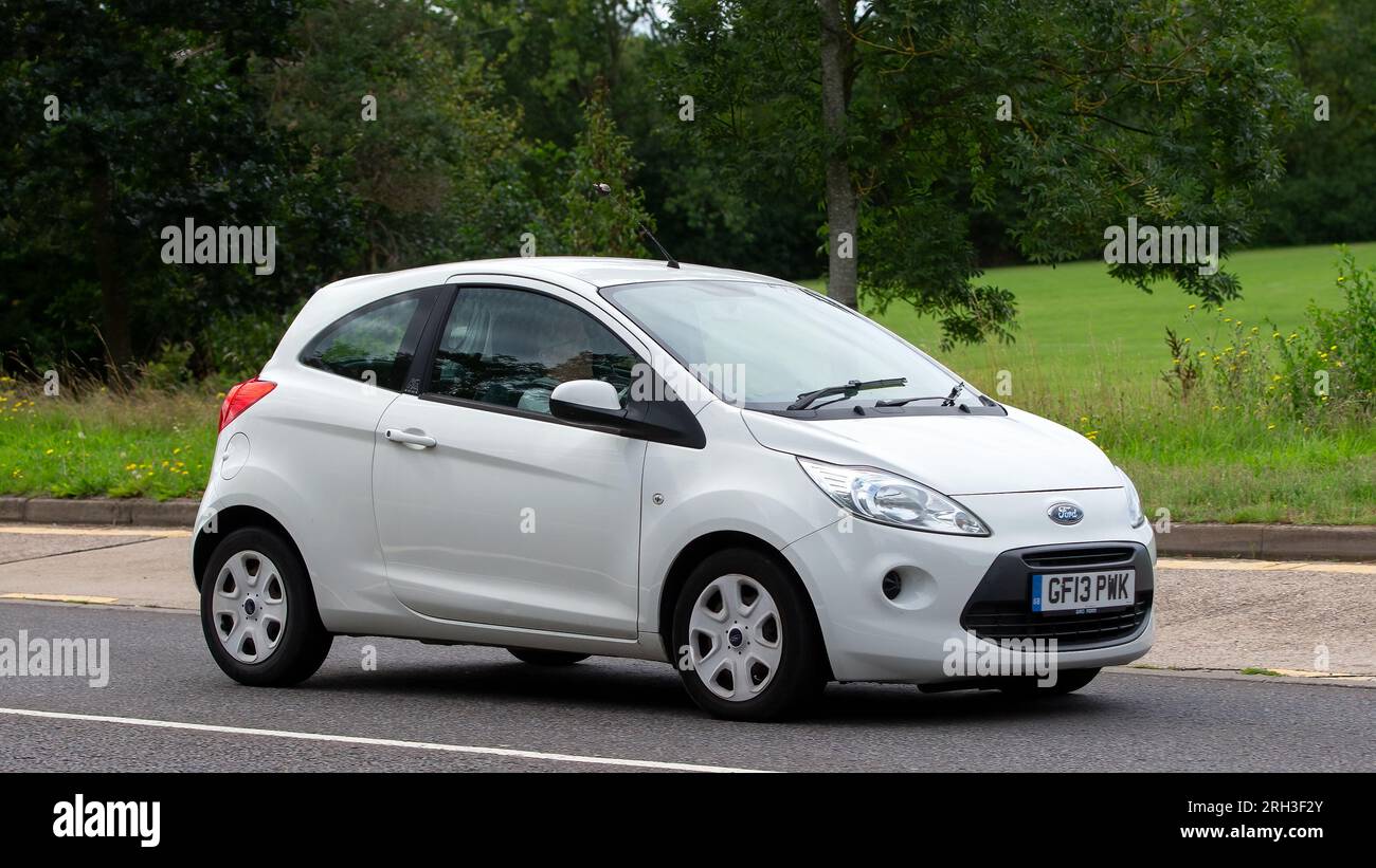 Milton Keynes, Regno Unito - 13 agosto 2023: 2013 Ford Ka bianca guida su una strada di campagna inglese. Foto Stock