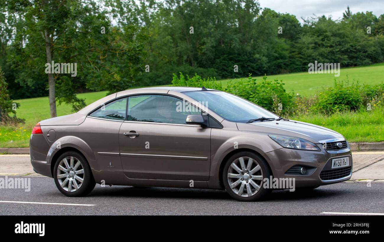 Milton Keynes, Regno Unito - 13 agosto 2023: Pininfarina design 2009 auto Ford Focus CC bronzo che guida su una strada di campagna inglese. Foto Stock