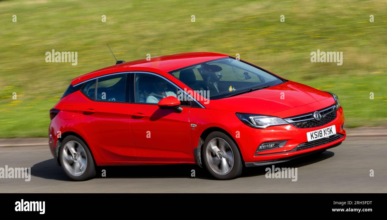 Milton Keynes, Regno Unito - 10 agosto 2023: 2018 auto rossa Vauxhall Astra che guida su una strada di campagna inglese. Foto Stock