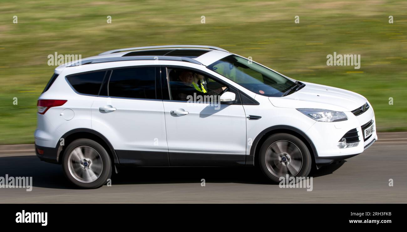 Milton Keynes, Regno Unito - 10 agosto 2023: 2014 auto Ford Kuga bianca che guida su una strada di campagna inglese. Foto Stock