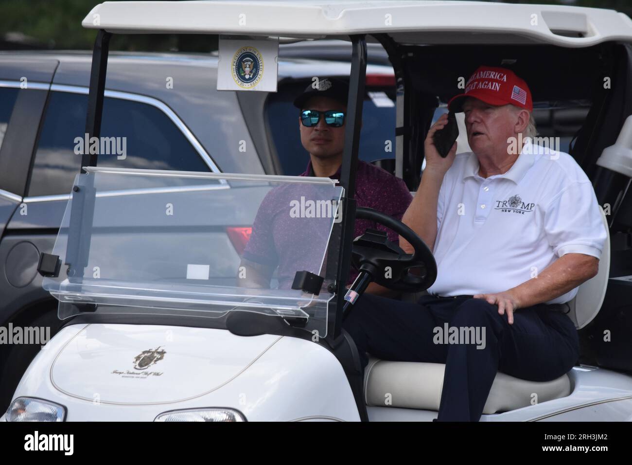 Bedminster, Stati Uniti. 13 agosto 2023. L'ex presidente degli Stati Uniti Donald J. Trump nel golf cart parla con qualcuno al telefono. L'ex presidente degli Stati Uniti Donald J. Trump (a destra) e Walt Nauta (a sinistra) guidano dal centro multimediale al LIV Golf Bedminster 2023 al Trump National Golf Club Bedminster. Credito: SOPA Images Limited/Alamy Live News Foto Stock