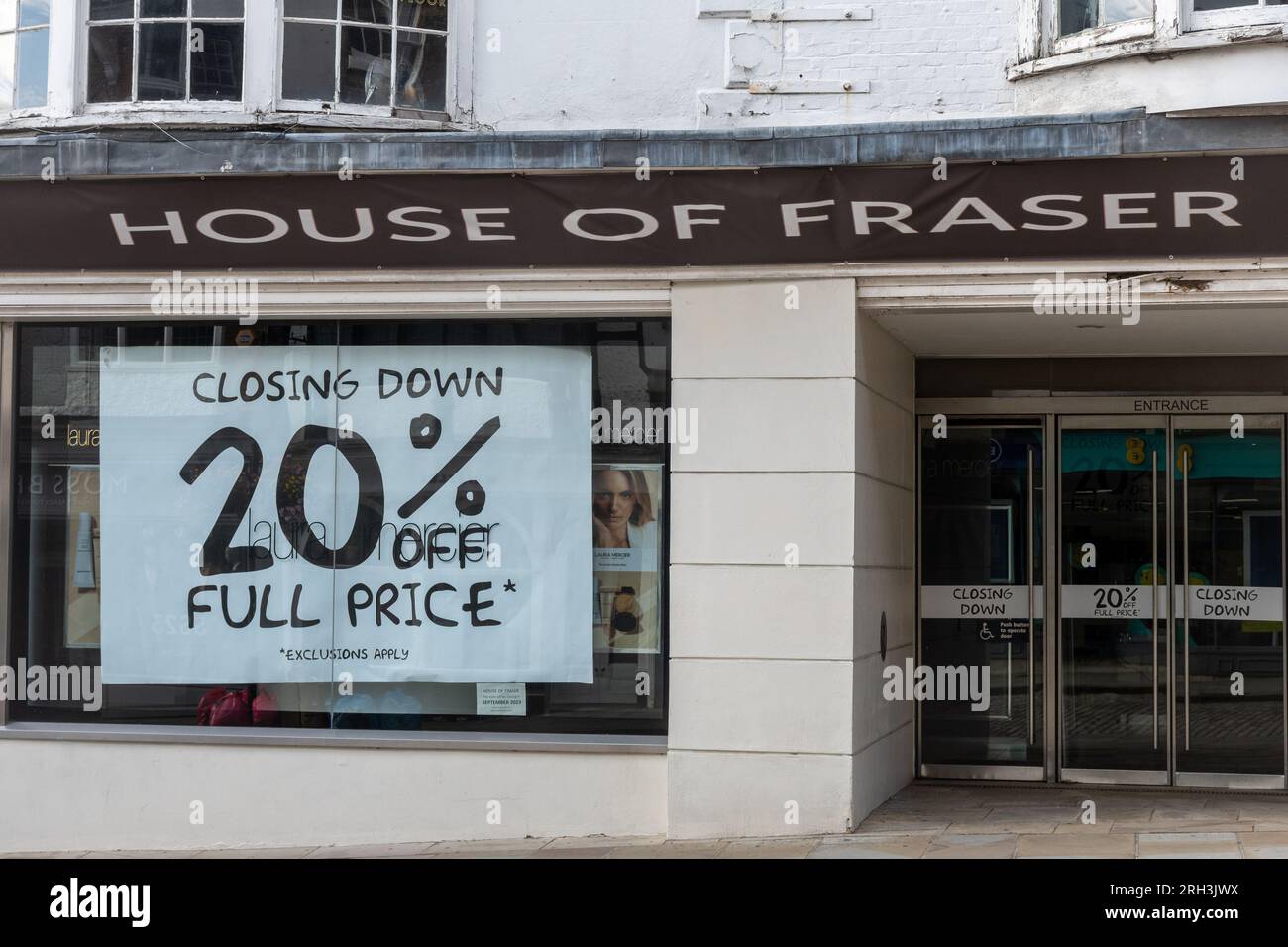 Il grande magazzino House of Fraser a Guildford, Surrey, Inghilterra, Regno Unito, chiuderà il 30 settembre 2023. Nella foto del 13 agosto 2023, grandi poster nelle vetrine del negozio di lusso pubblicizzano uno sconto del 20% sulla chiusura della vendita. Foto Stock