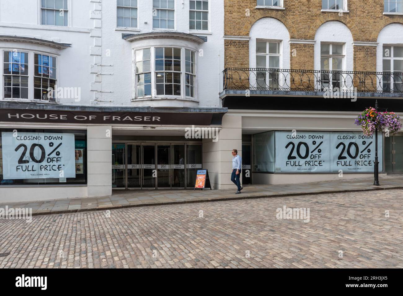 Il grande magazzino House of Fraser a Guildford, Surrey, Inghilterra, Regno Unito, chiuderà il 30 settembre 2023. Nella foto del 13 agosto 2023, grandi poster nelle vetrine del negozio di lusso pubblicizzano uno sconto del 20% sulla chiusura della vendita. Foto Stock