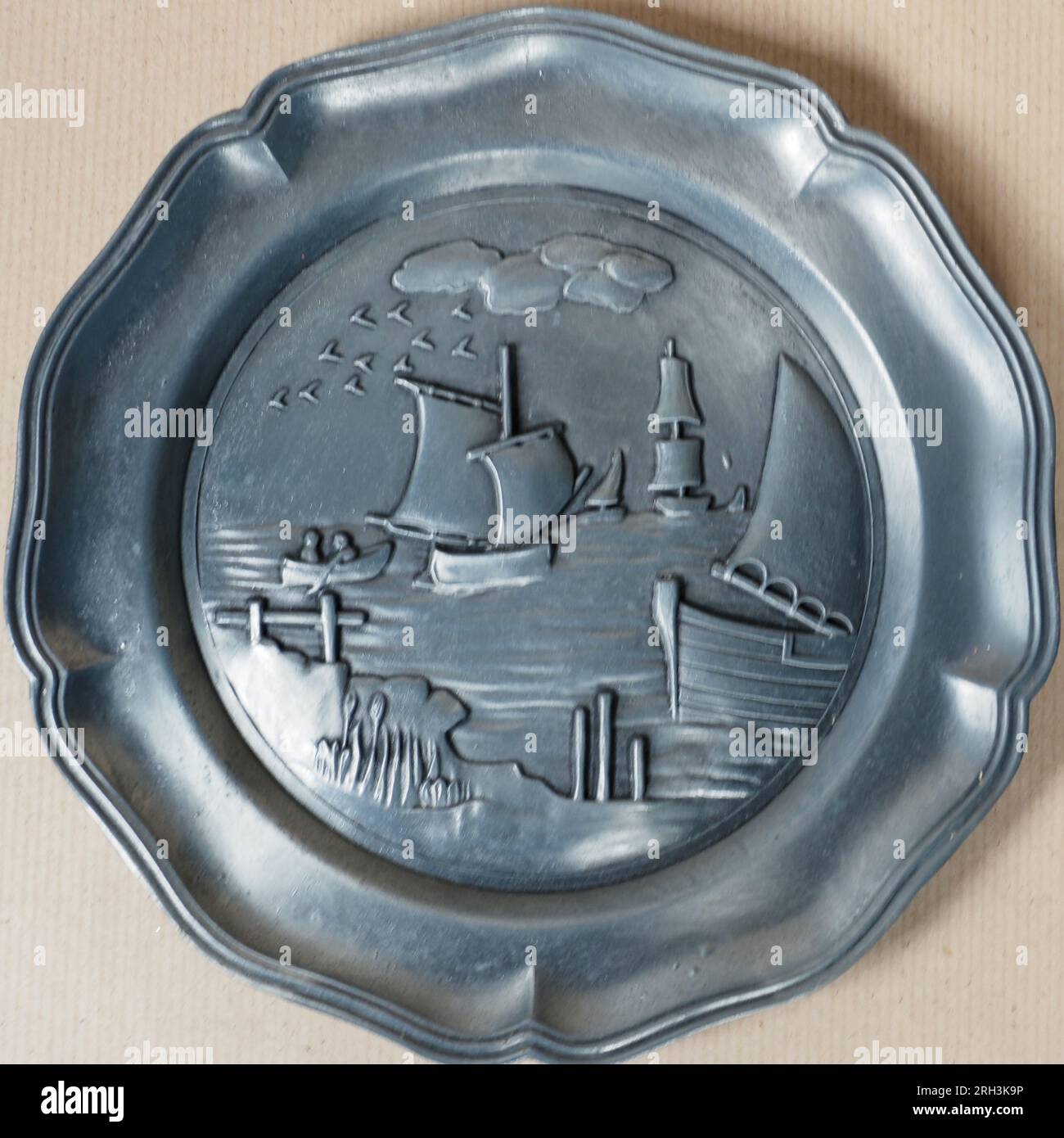 Tradizionale piatto decorativo in peltro antico tedesco che raffigura le navi a vela in mare Foto Stock