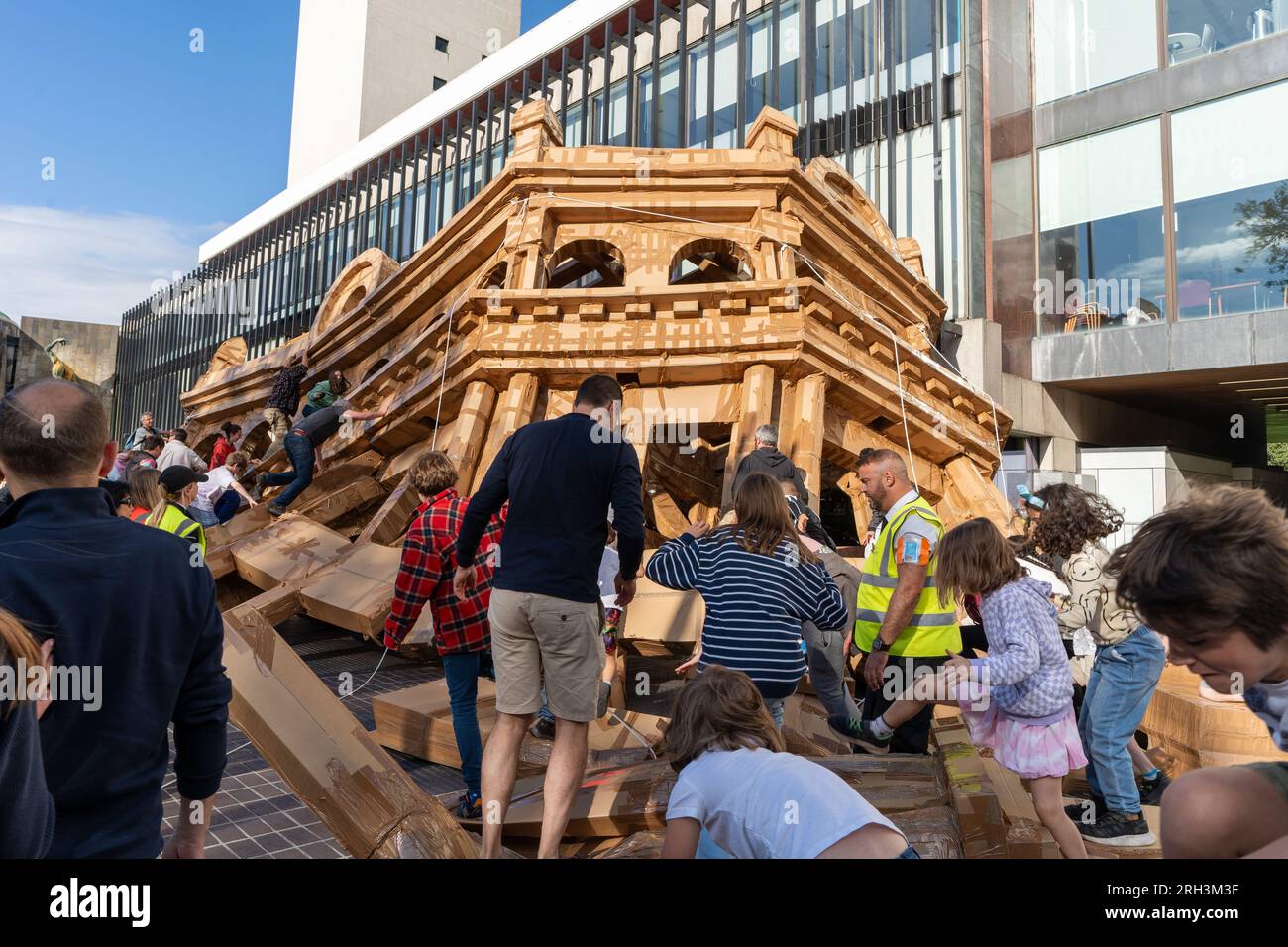 Newcastle upon Tyne, Regno Unito. 13 agosto 2023. Novum Summer Festival - demolizione della "costruzione monumentale" - un edificio in cartone di 45 piedi (14 metri) creato dall'artista visuale francese Olivier Grossetête e da volontari, e poi decostruito. Novum è un nuovissimo festival multi-arte che mette in mostra talenti locali, nazionali e internazionali presso il Centro Civico della città. -- l'edificio è distrutto dal pubblico. Crediti: Hazel Plater/Alamy Live News Foto Stock