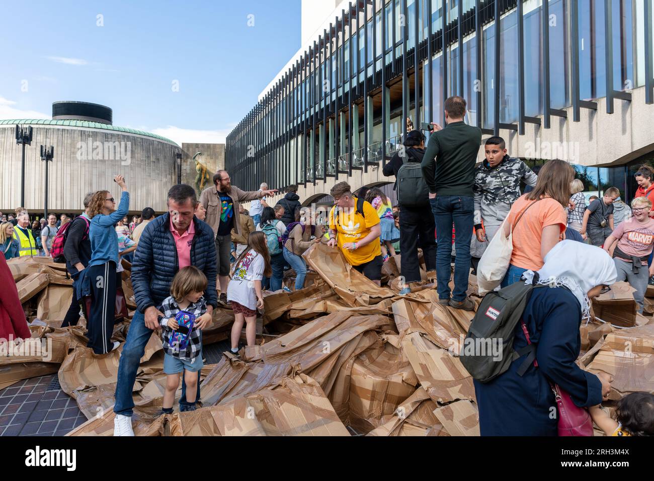 Newcastle upon Tyne, Regno Unito. 13 agosto 2023. Novum Summer Festival - demolizione della "costruzione monumentale" - un edificio in cartone di 45 piedi (14 metri) creato dall'artista visuale francese Olivier Grossetête e da volontari, e poi decostruito. Novum è un nuovissimo festival multi-arte che mette in mostra talenti locali, nazionali e internazionali presso il Centro Civico della città. -- l'edificio è distrutto dal pubblico. Crediti: Hazel Plater/Alamy Live News Foto Stock