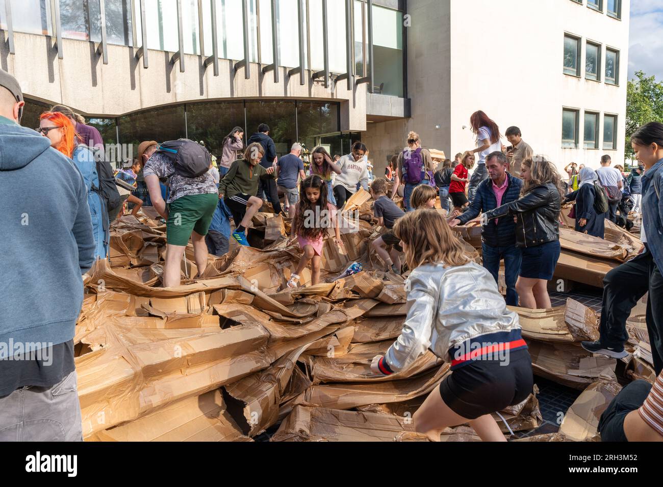 Newcastle upon Tyne, Regno Unito. 13 agosto 2023. Novum Summer Festival - demolizione della "costruzione monumentale" - un edificio in cartone di 45 piedi (14 metri) creato dall'artista visuale francese Olivier Grossetête e da volontari, e poi decostruito. Novum è un nuovissimo festival multi-arte che mette in mostra talenti locali, nazionali e internazionali presso il Centro Civico della città. -- l'edificio è smembrato dal pubblico. Crediti: Hazel Plater/Alamy Live News Foto Stock