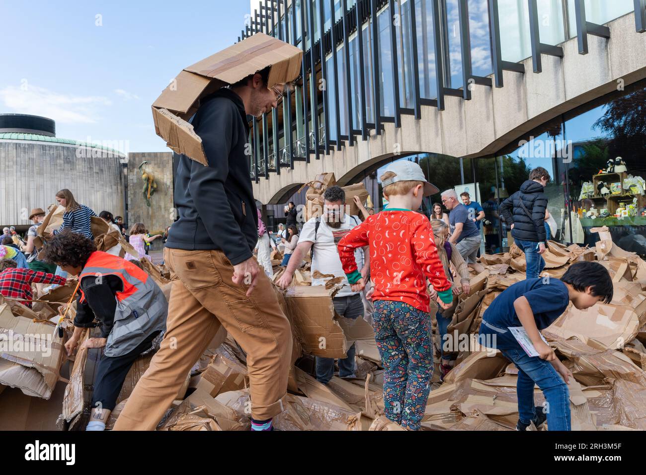 Newcastle upon Tyne, Regno Unito. 13 agosto 2023. Novum Summer Festival - demolizione della "costruzione monumentale" - un edificio in cartone di 45 piedi (14 metri) creato dall'artista visuale francese Olivier Grossetête e da volontari, e poi decostruito. Novum è un nuovissimo festival multi-arte che mette in mostra talenti locali, nazionali e internazionali presso il Centro Civico della città. -- l'edificio è smembrato dal pubblico. Crediti: Hazel Plater/Alamy Live News Foto Stock