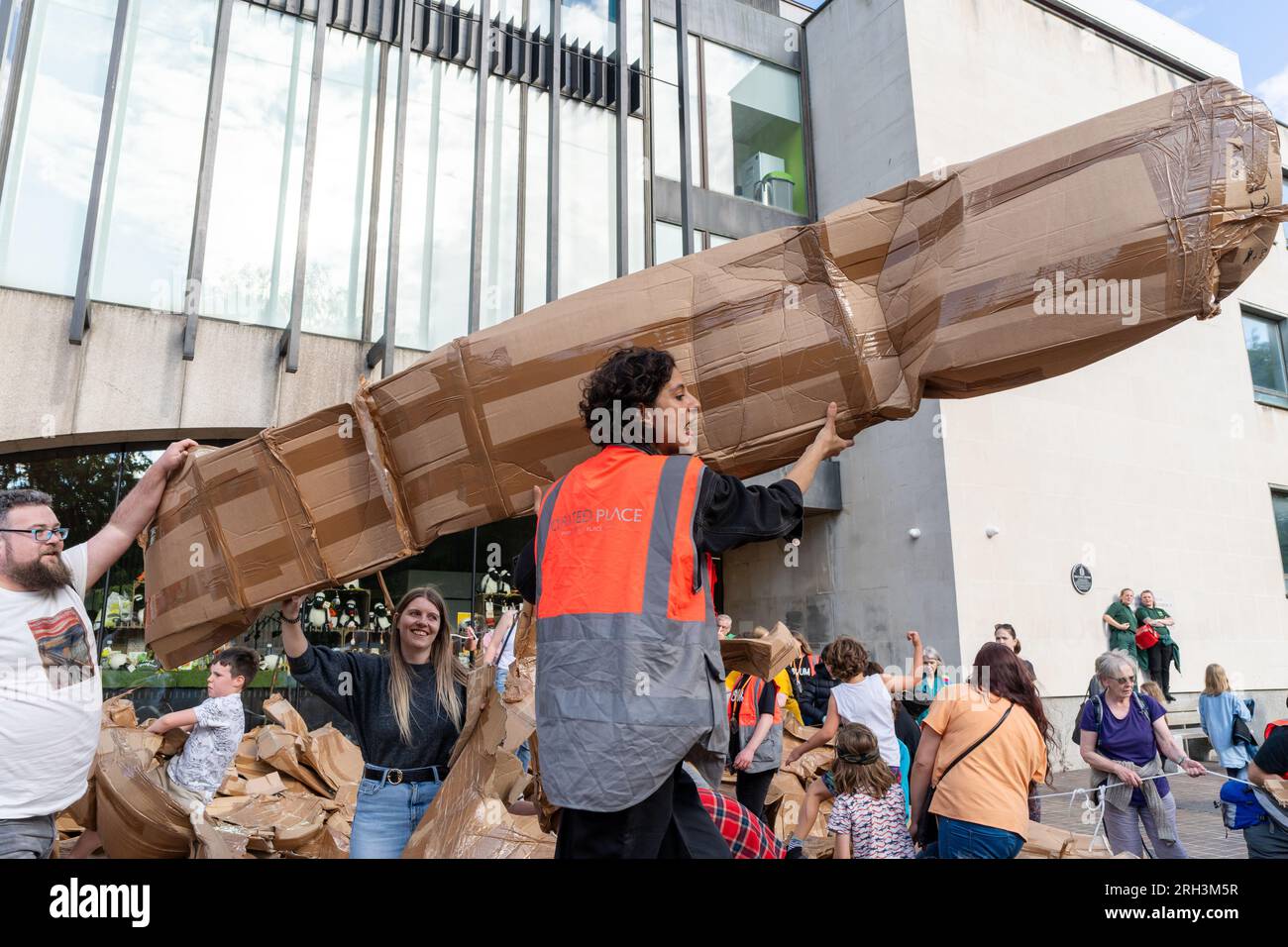 Newcastle upon Tyne, Regno Unito. 13 agosto 2023. Novum Summer Festival - demolizione della "costruzione monumentale" - un edificio in cartone di 45 piedi (14 metri) creato dall'artista visuale francese Olivier Grossetête e da volontari, e poi decostruito. Novum è un nuovissimo festival multi-arte che mette in mostra talenti locali, nazionali e internazionali presso il Centro Civico della città. -- l'edificio è smembrato dal pubblico. Crediti: Hazel Plater/Alamy Live News Foto Stock