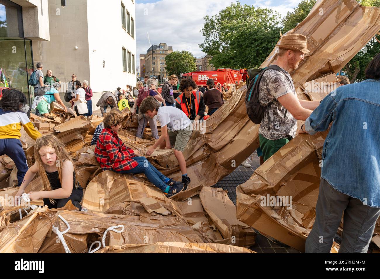 Newcastle upon Tyne, Regno Unito. 13 agosto 2023. Novum Summer Festival - demolizione della "costruzione monumentale" - un edificio in cartone di 45 piedi (14 metri) creato dall'artista visuale francese Olivier Grossetête e da volontari, e poi decostruito. Novum è un nuovissimo festival multi-arte che mette in mostra talenti locali, nazionali e internazionali presso il Centro Civico della città. -- l'edificio è smembrato dal pubblico. Crediti: Hazel Plater/Alamy Live News Foto Stock