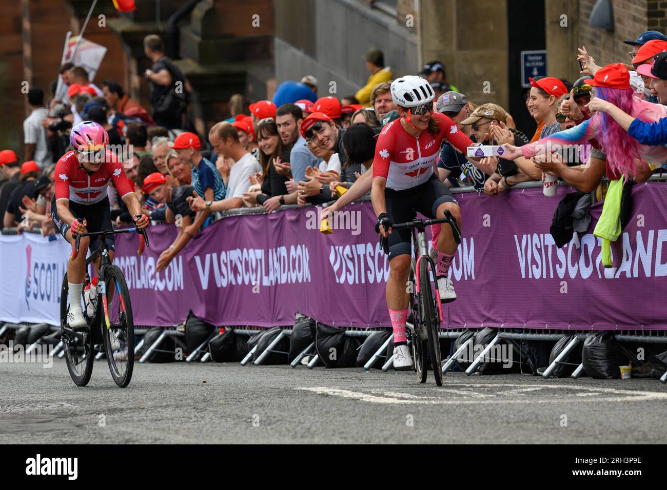 Glasgow, Scozia. 13 agosto 2023. Un concorrente canadese che accetta una scatola di ciambelle da uno spettatore durante la UCI Womens Elite Cycling Race Foto Stock