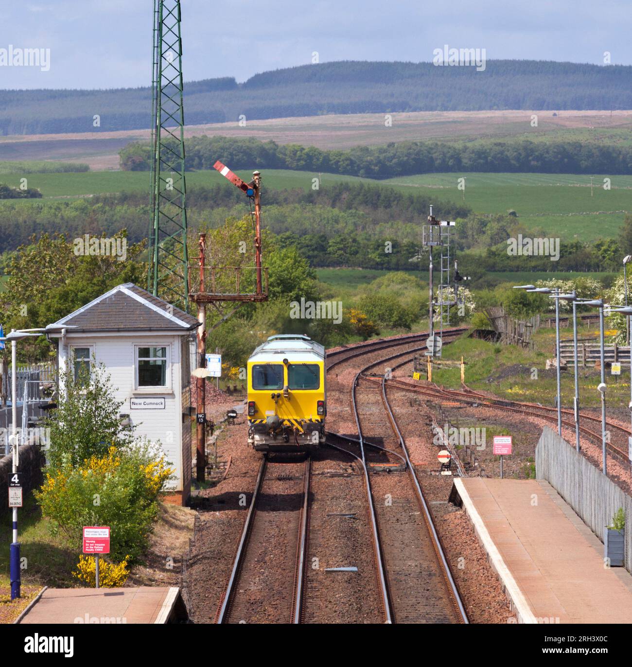 La macchina per la compattazione di binari ferroviari passa la scatola di segnalazione meccanica e il segnale del semaforo a staffa alta a New Cumnock, Ayrshire, Scozia, Regno Unito Foto Stock