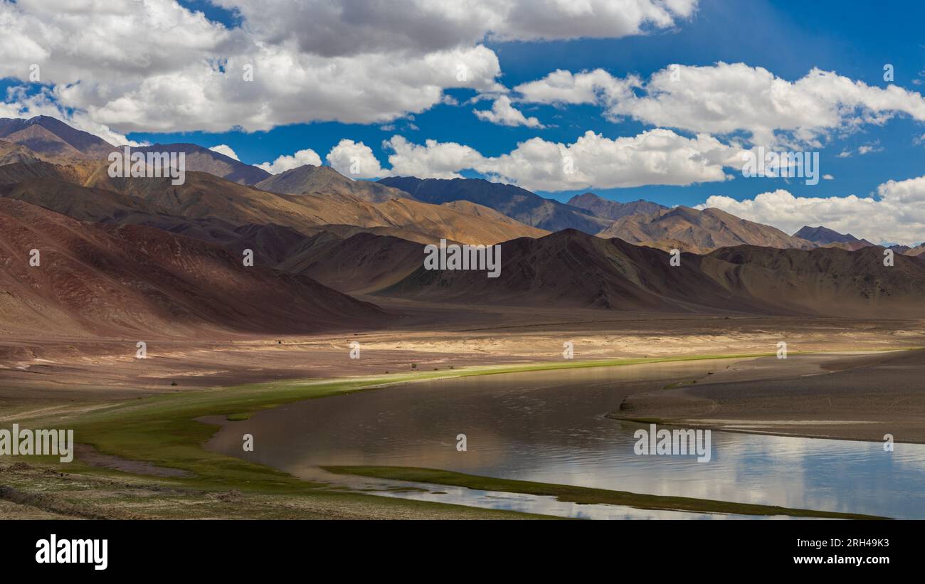 Una valle aperta in Ladakh con un fiume che scorre al centro e nuvole all'orizzonte Foto Stock