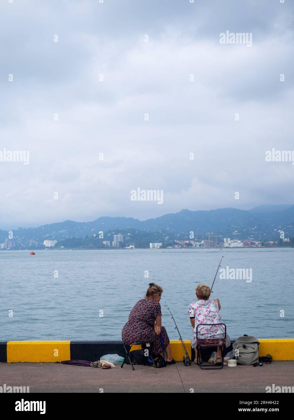 Le donne della pesca. Pescatori vicino alle navi. Gente al molo. Hobby preferito. A Port. Cibo di famiglia. persone con canne da pesca Foto Stock