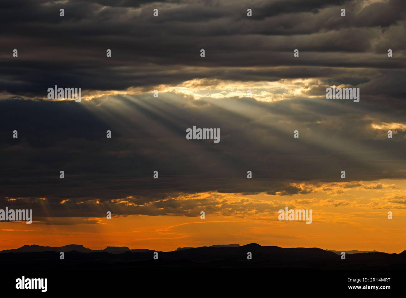 Suggestivo paesaggio nuvoloso all'alba con raggi del sole sulle cime delle montagne, Sud Africa Foto Stock