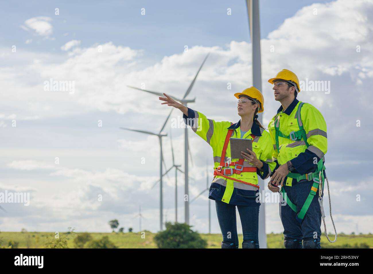 Team di ingegneri, uomo e donna, che lavorano sul campo, piano di indagine, costruzione di turbine eoliche, generatore di energia pulita Foto Stock Team di ingegneri, uomo e donna, che lavorano sul campo, piano di indagine, costruzione di turbine eoliche, generatore di energia pulita Foto Stock