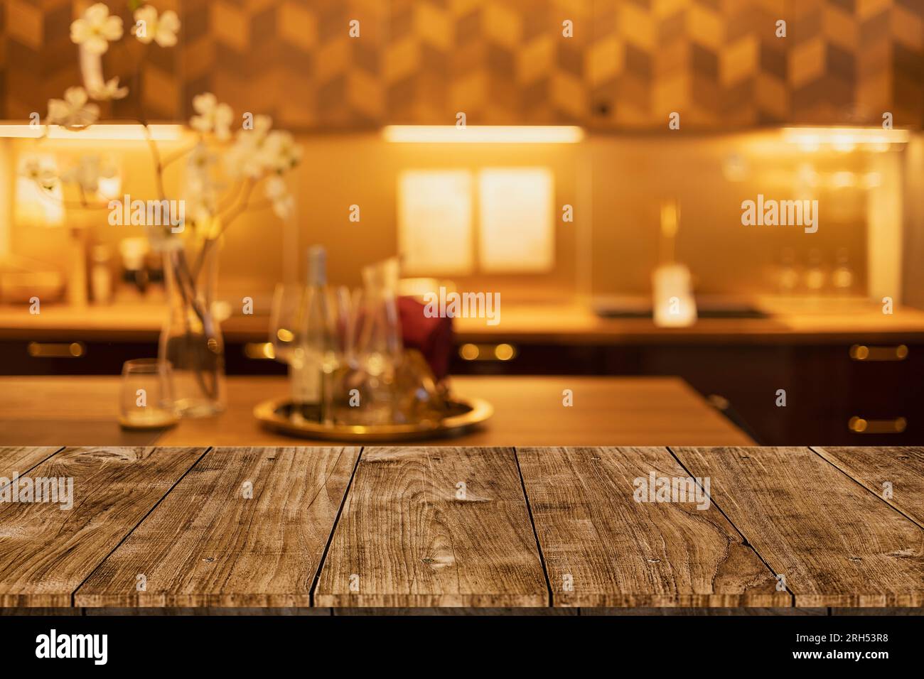 moderna e lussuosa cucina dai toni caldi dorati neri con spazio da tavolo in legno per montare i prodotti da esposizione. Foto Stock