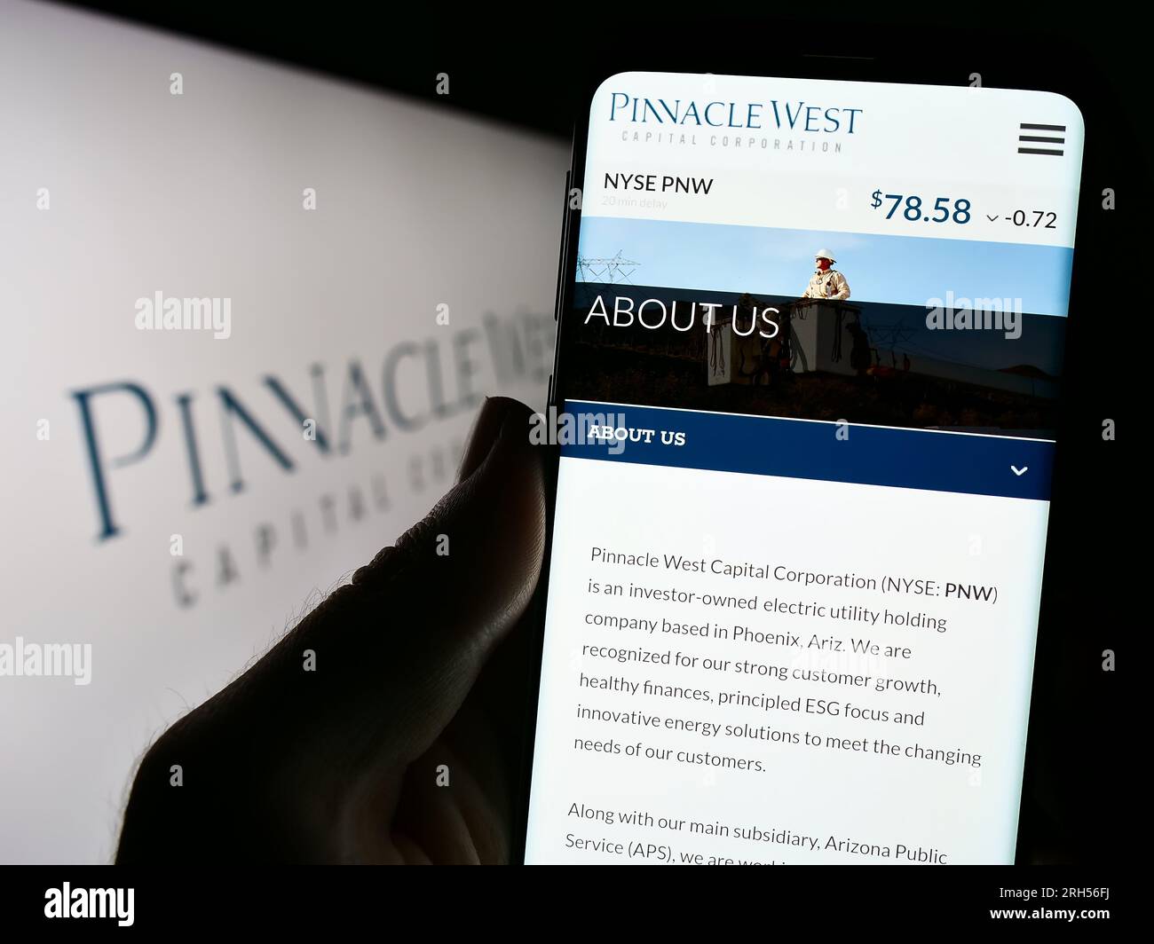 Persona in possesso di cellulare con pagina Web della società statunitense Pinnacle West Capital Corporation sullo schermo con logo. Concentrarsi sul centro del display del telefono. Foto Stock