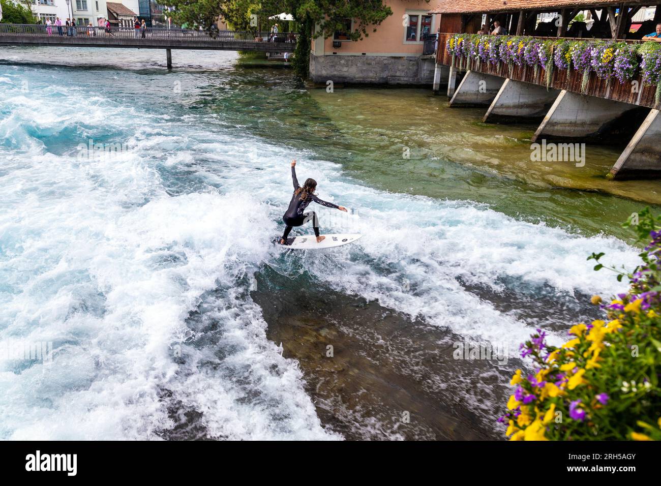Donna che fa surf sul fiume all'Untere Schleuse Brücke a Thun, in Svizzera Foto Stock