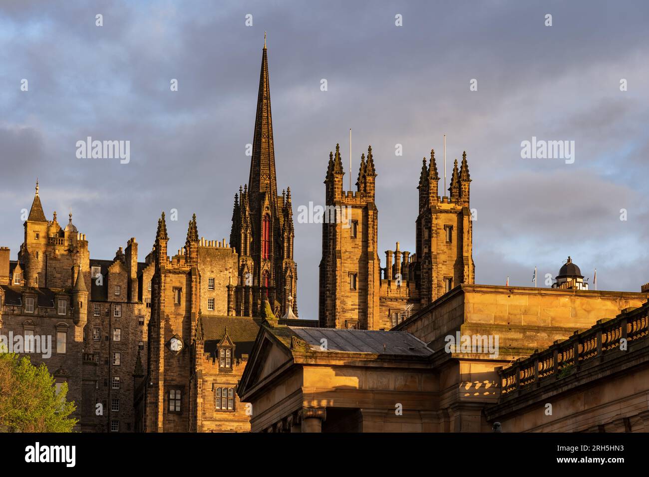 Città vecchia di Edimburgo al tramonto con le torri del New College sul tumulo e la guglia dell'edificio Hub, ex chiesa di Tolbooth in Scozia, Regno Unito. Foto Stock