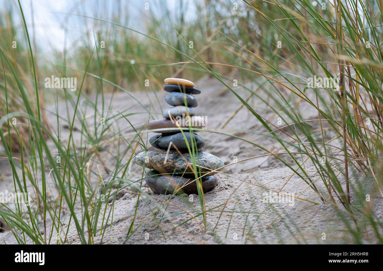 Mucchio di pietra nelle dune di sabbia della spiaggia. Foto Stock