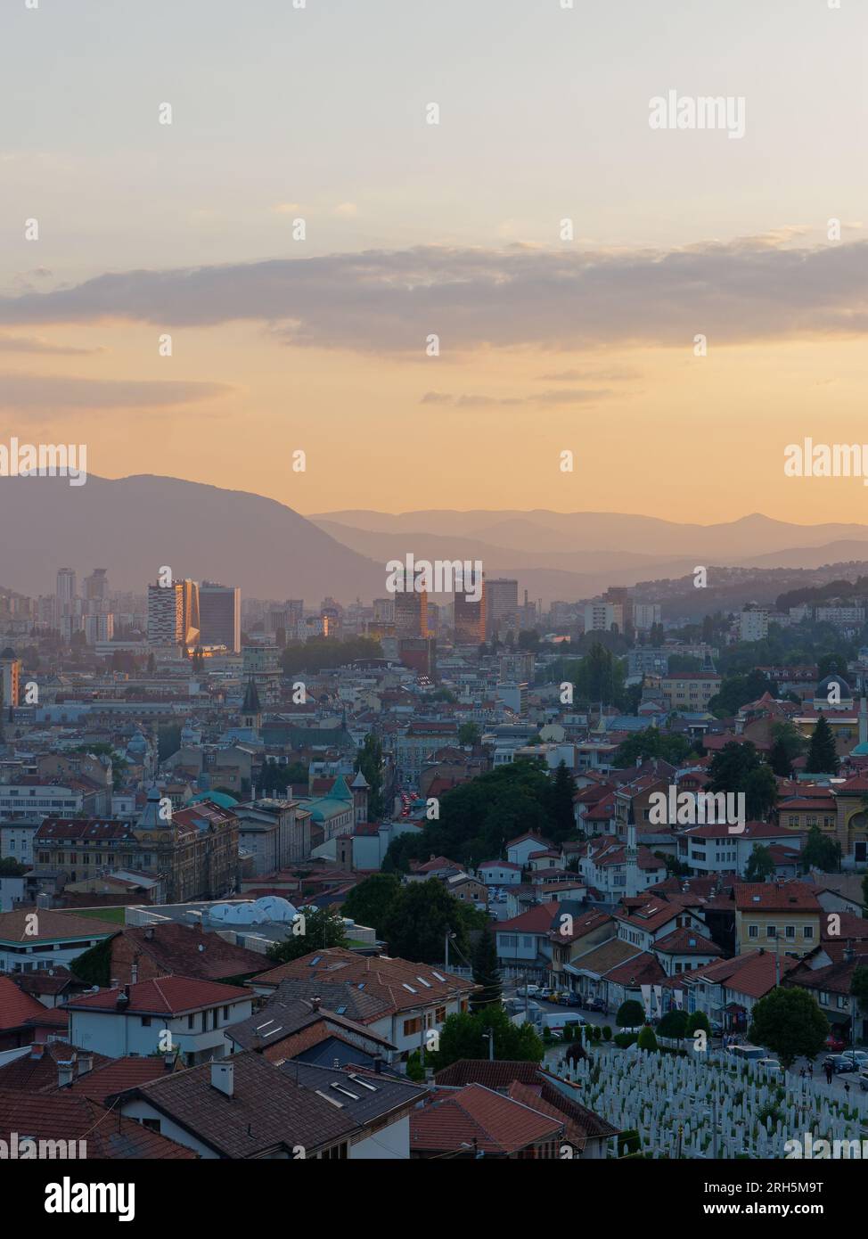 Vista sopraelevata sulla città di Sarajevo al tramonto con blocchi di appartamenti e montagne sullo sfondo, Bosnia ed Erzegovina, 13 agosto 2023. Foto Stock