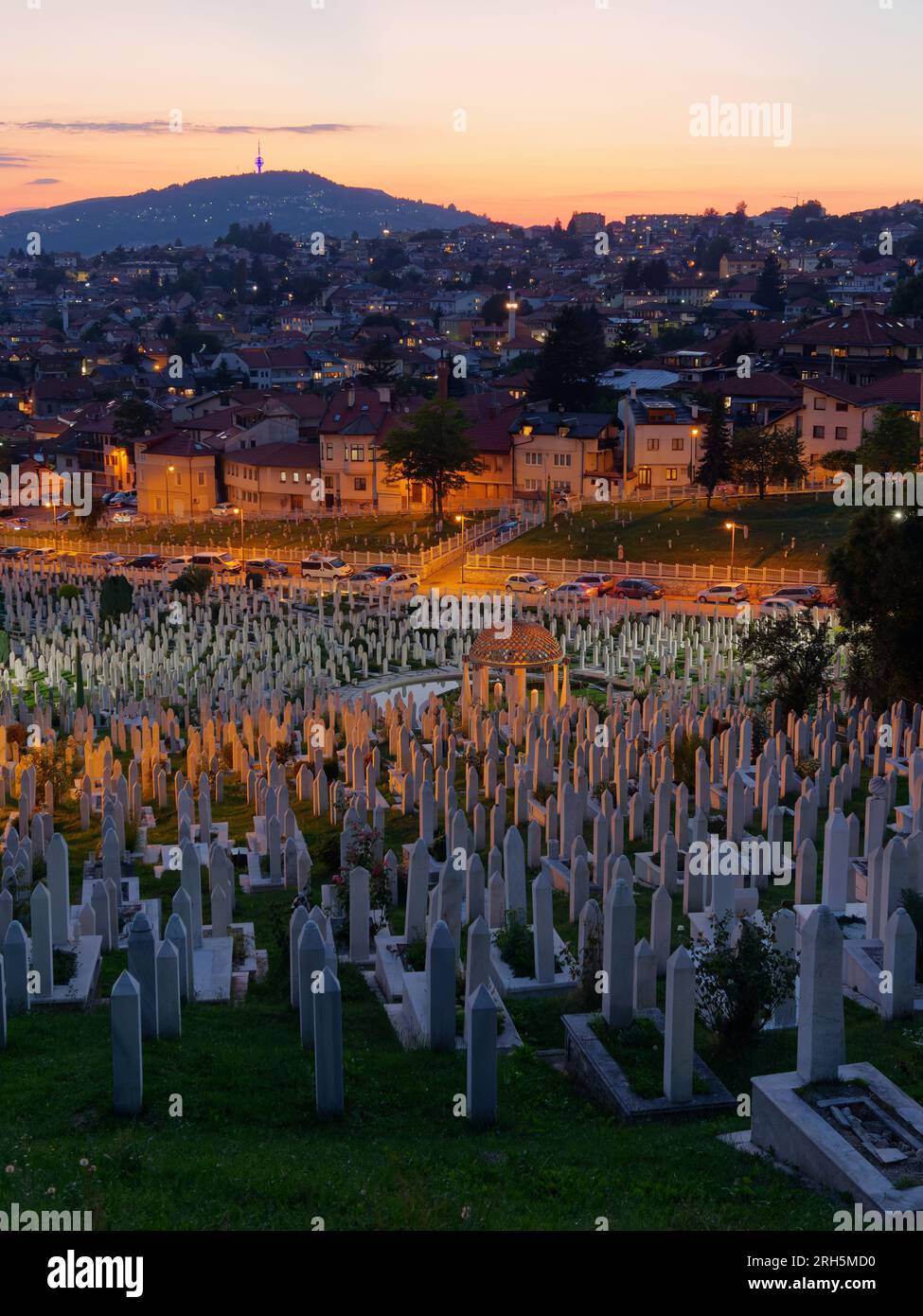 Cimitero notturno con case sulla collina dietro la città di Sarajevo, Bosnia ed Erzegovina, 13 agosto 2023. Foto Stock