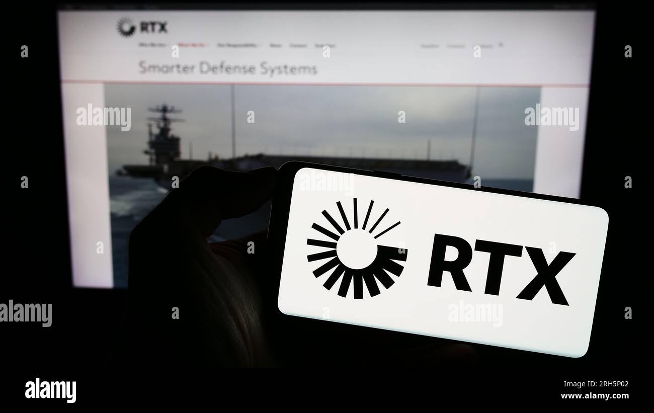 Persona che possiede un telefono cellulare con il logo della società statunitense per il settore aerospaziale e della difesa RTX Corporation sullo schermo davanti alla pagina Web. Concentrarsi sul display del telefono. Foto Stock