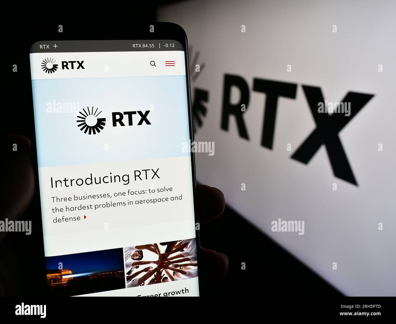 Persona che tiene il cellulare con una pagina Web della società statunitense per il settore aerospaziale e della difesa RTX Corporation sullo schermo con logo. Concentrarsi sul centro del display del telefono. Foto Stock