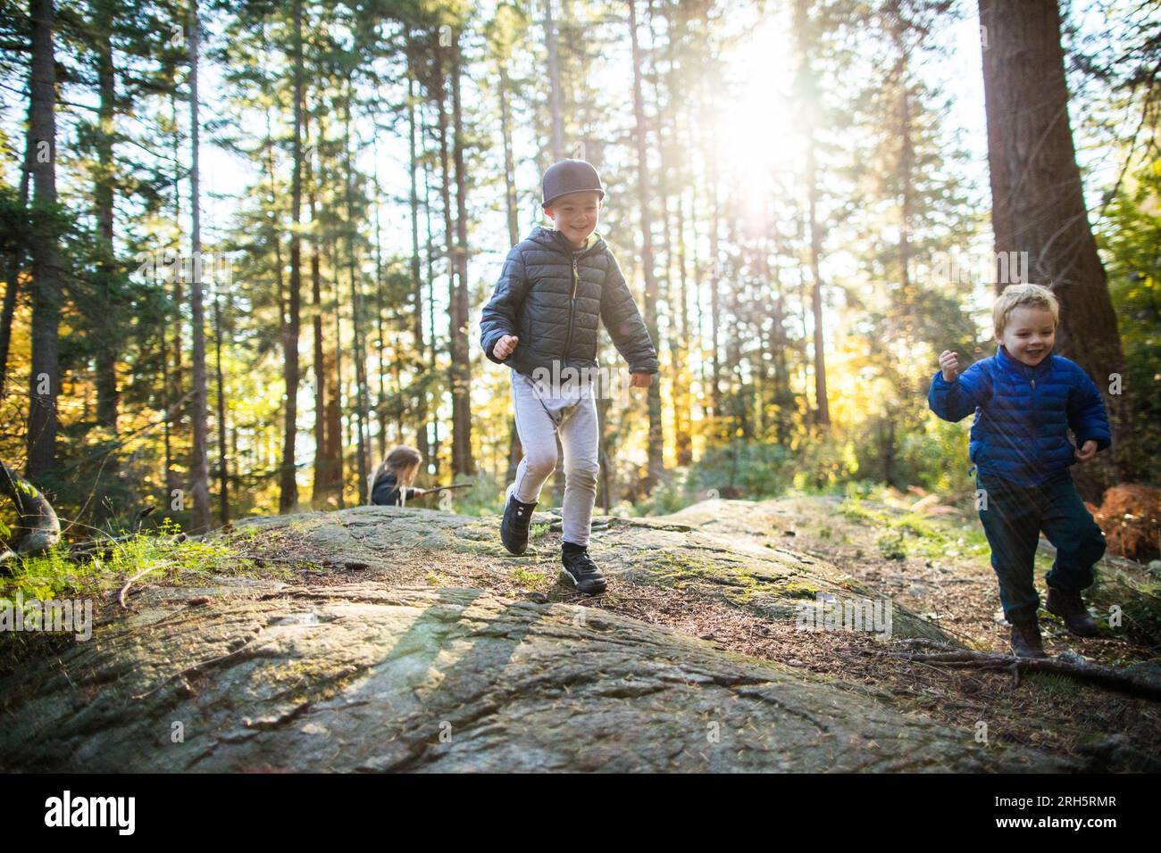 Due ragazzi che giocano ed esplorano la natura sotto il sole Foto Stock