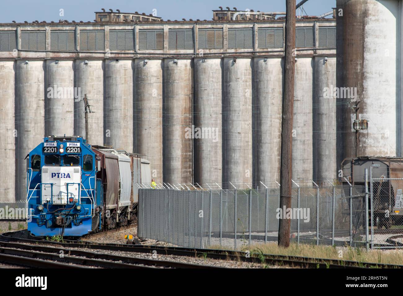 Una locomotiva cambia auto intorno a un impianto di produzione di grano industriale. Foto Stock