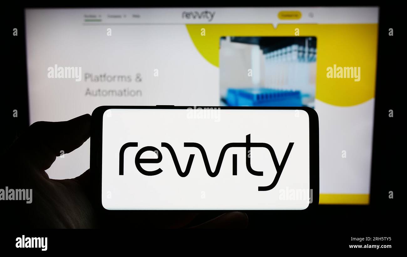 Persona in possesso di un cellulare con il logo della società statunitense Revvity Inc. Sullo schermo di fronte alla pagina Web aziendale. Concentrarsi sul display del telefono. Foto Stock
