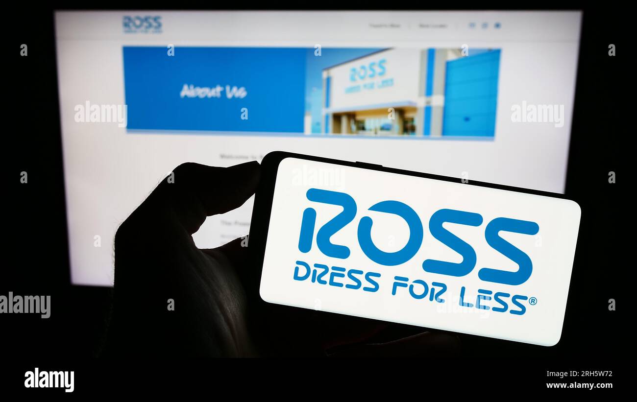 Persona che possiede uno smartphone con il logo della società di vendita al dettaglio statunitense Ross Stores Inc. Sullo schermo di fronte al sito Web. Concentrarsi sul display del telefono. Foto Stock