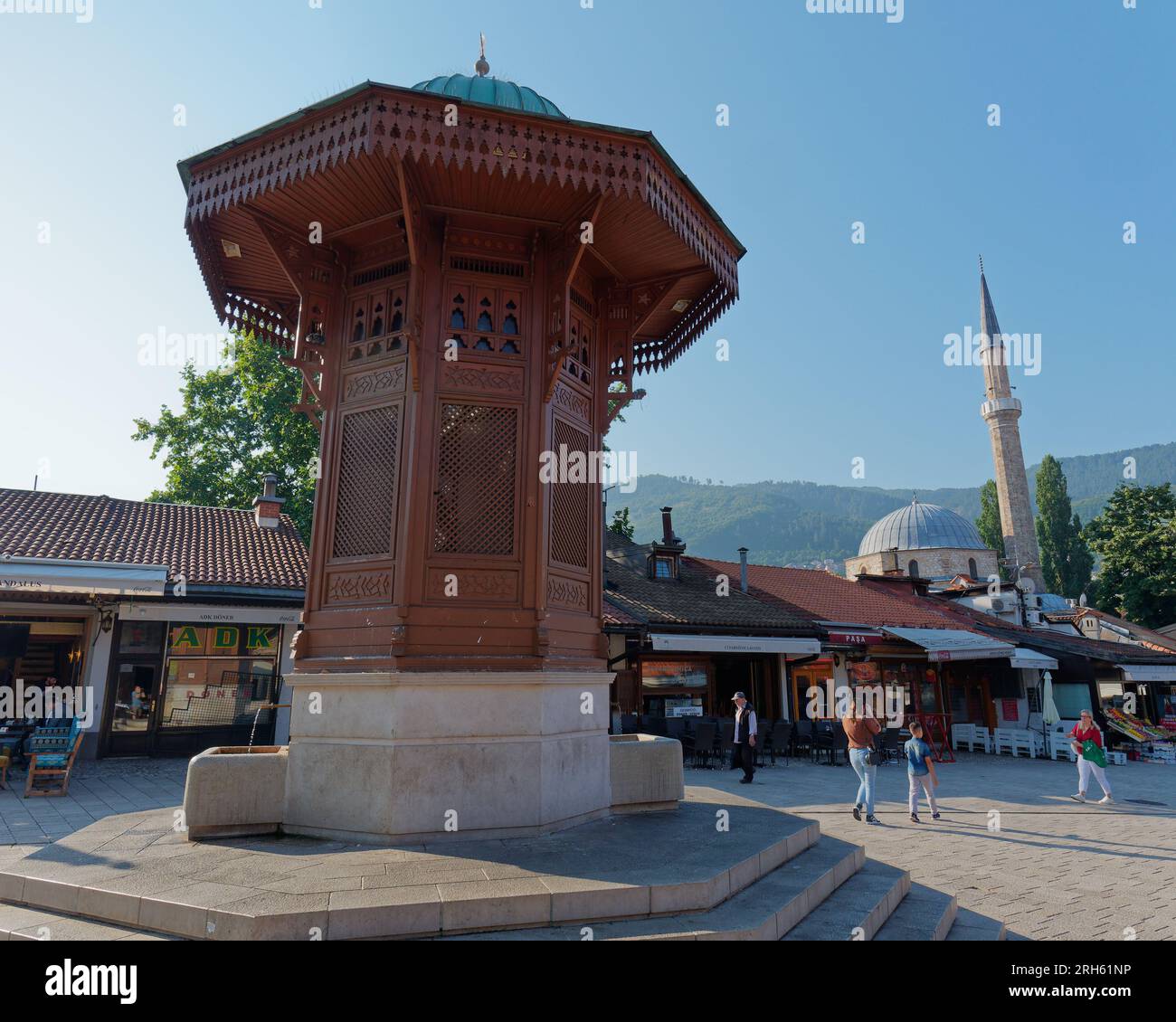 Turisti intorno al Sebilj, una fontana in stile ottomano nel quartiere Baščaršija di Sarajevo, Bosnia ed Erzegovina, 14 agosto 2023. Foto Stock