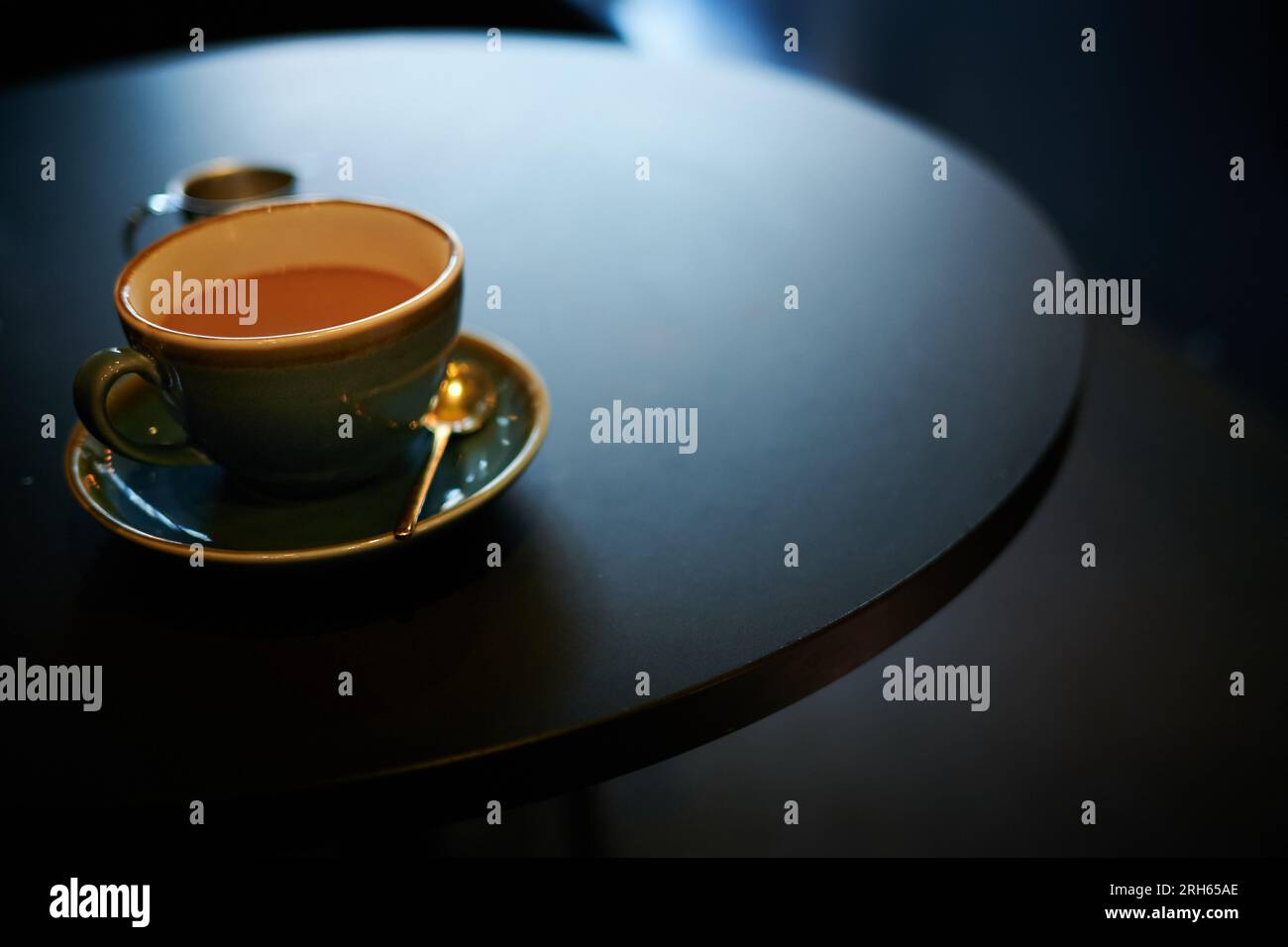 Caffè in una tazza e piattino su un tavolo Foto Stock