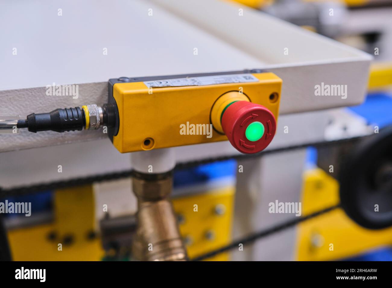 grande pulsante rosso in fabbrica. base gialla, pulsante rosso e luce verde sul pulsante rosso. Foto Stock