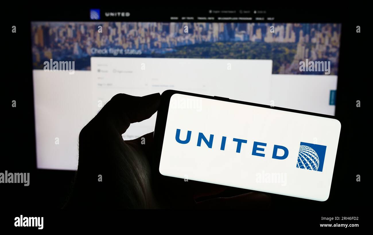 Persona che possiede uno smartphone con il logo della società statunitense United Airlines Holdings Inc. Sullo schermo davanti al sito Web. Concentrarsi sul display del telefono. Foto Stock