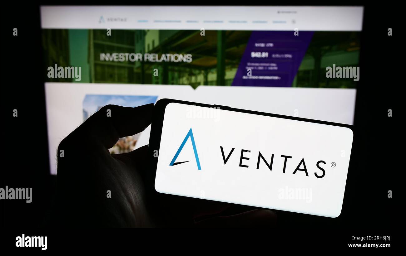 Persona che possiede un telefono cellulare con il logo della società immobiliare americana Ventas Inc. Sullo schermo davanti alla pagina Web aziendale. Concentrarsi sul display del telefono. Foto Stock
