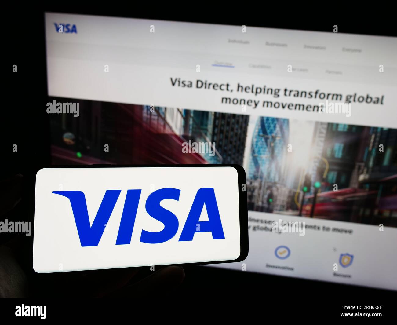 Persona in possesso di un cellulare con il logo della società statunitense di elaborazione dei pagamenti Visa Inc. Sullo schermo di fronte alla pagina Web aziendale. Concentrarsi sul display del telefono. Foto Stock