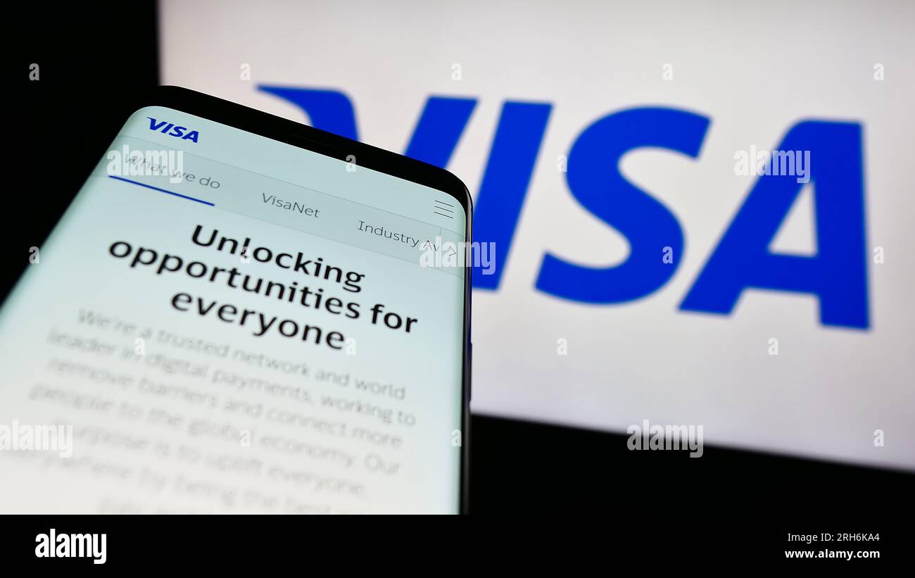 Smartphone con sito Web della società statunitense di elaborazione dei pagamenti Visa Inc. Sullo schermo di fronte al logo aziendale. Mettere a fuoco in alto a sinistra sul display del telefono. Foto Stock