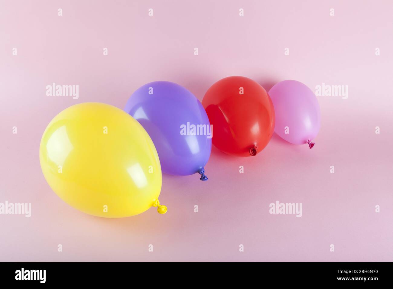 palloncini dai colori armoniosi su sfondo rosa. Fotografia a colori minimalista. Foto Stock