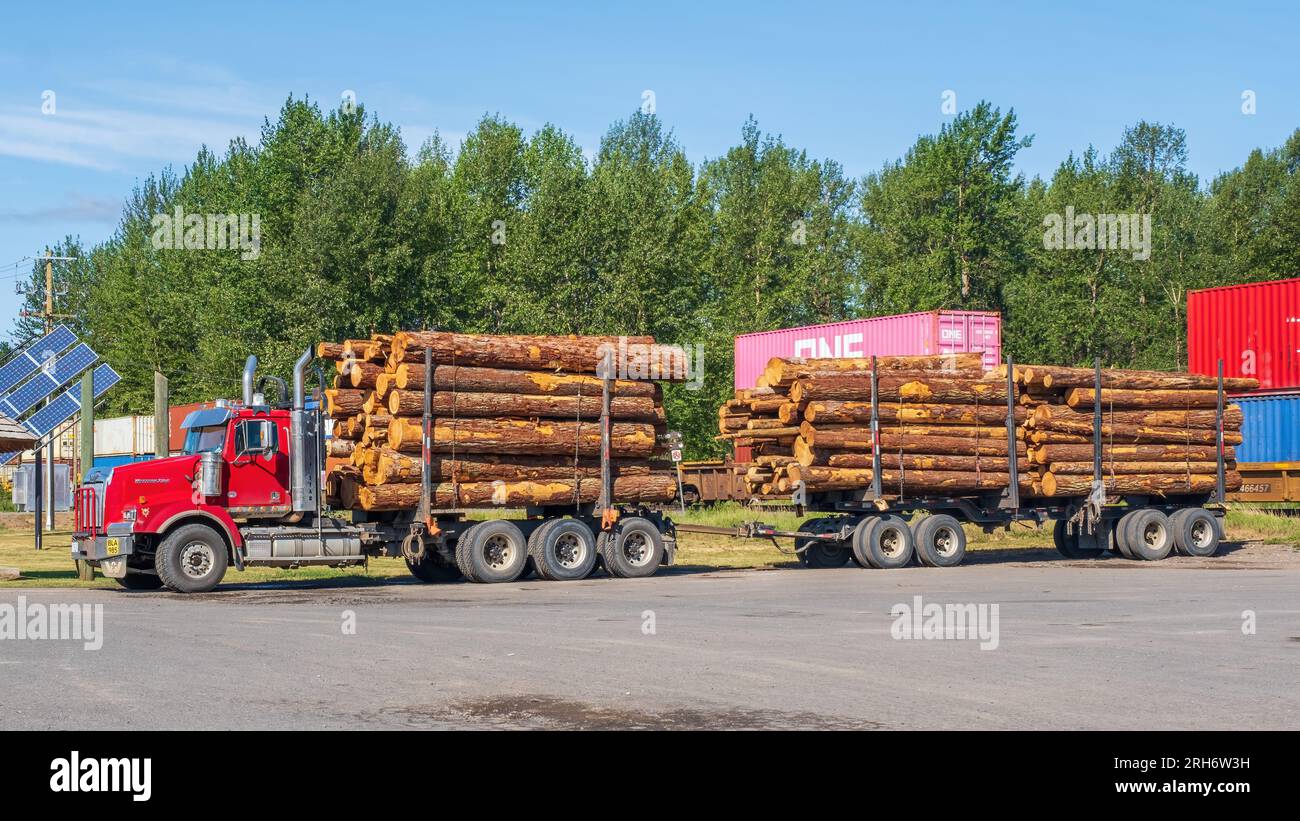 Camion e rimorchio carichi di tronchi tagliati in un parcheggio a Houston, British Columbia. La Columbia Britannica è uno dei più grandi esportatori al mondo di legno p Foto Stock