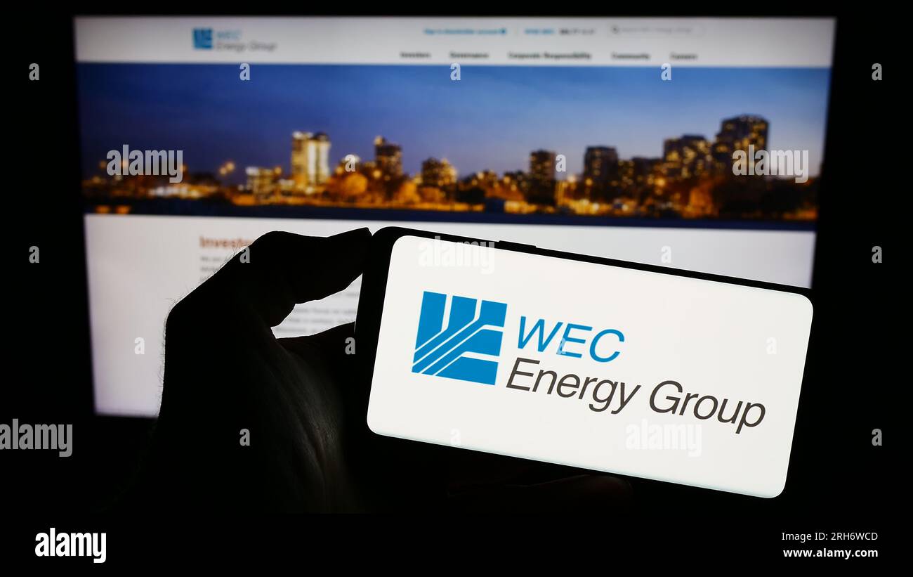 Persona che possiede uno smartphone con il logo della società statunitense WEC Energy Group Inc. Sullo schermo davanti al sito Web. Concentrarsi sul display del telefono. Foto Stock