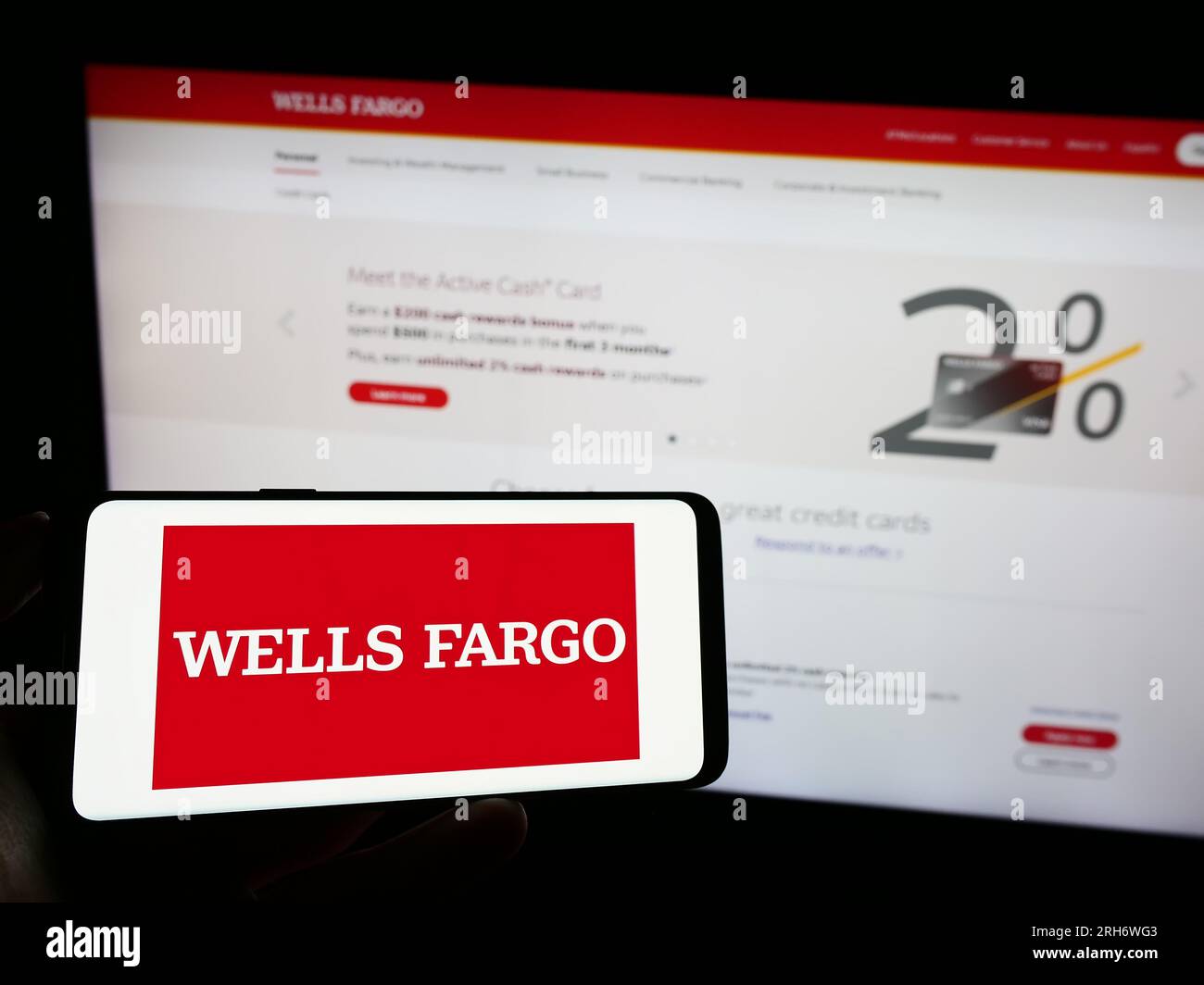 Persona in possesso di un cellulare con il logo dell'azienda finanziaria statunitense Wells Fargo Company sullo schermo davanti alla pagina Web. Concentrarsi sul display del telefono. Foto Stock