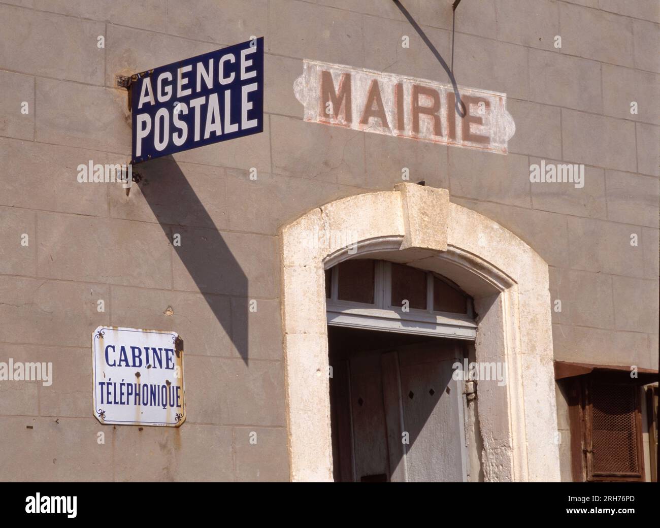 MAUBEC, FRANCIA- AGOSTO 2023: Muro del |C|ity Hall con dipinto sul muro la parola Mairie che significa municipio e un cartello stradale con il francese W Foto Stock