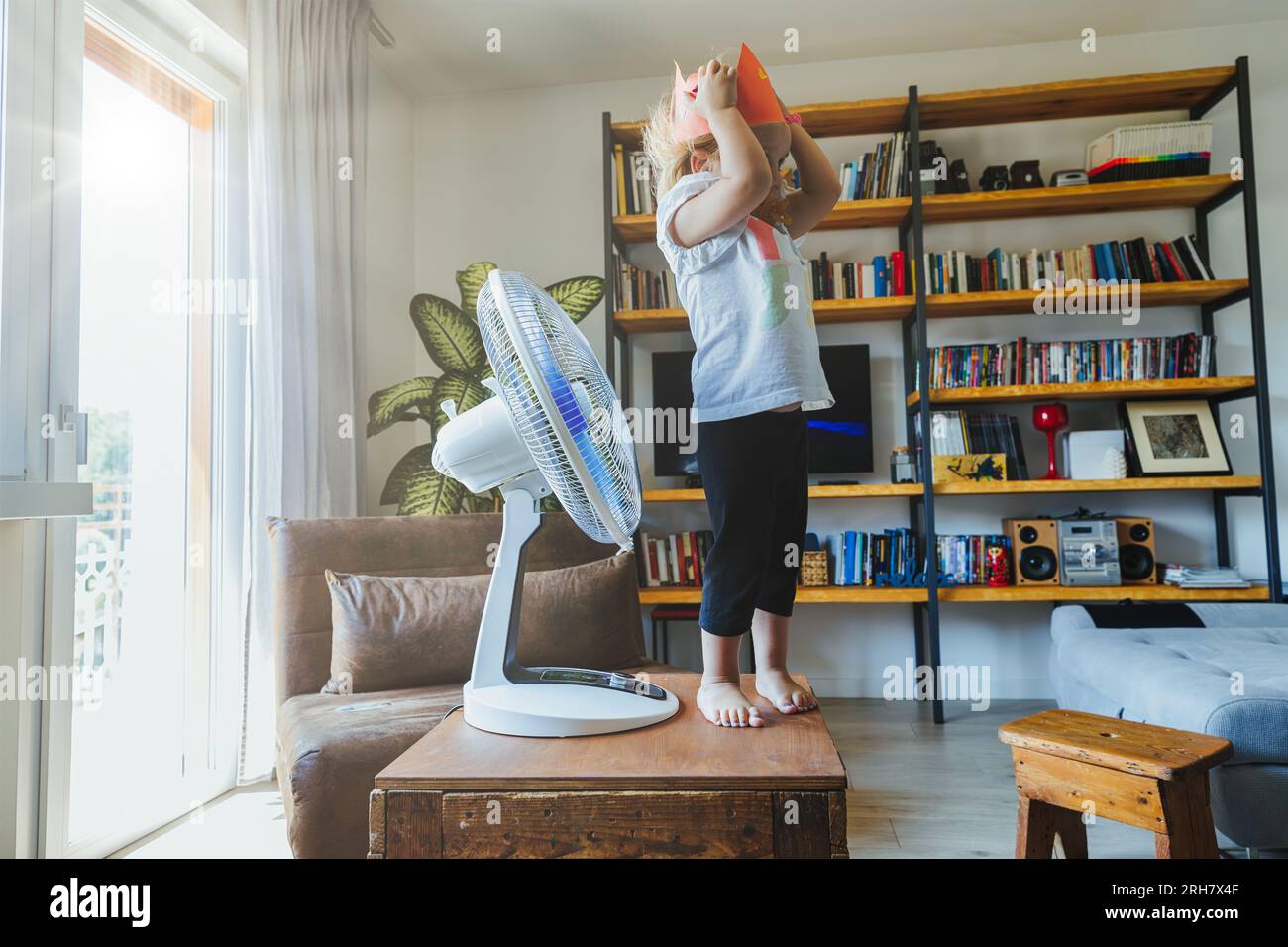 Madre e figlia apprezzano la freschezza, la danza e il volo dei fan. Sapiente divertimento in caldo, alla ricerca di una rinfrescata fresca con gioia Foto Stock