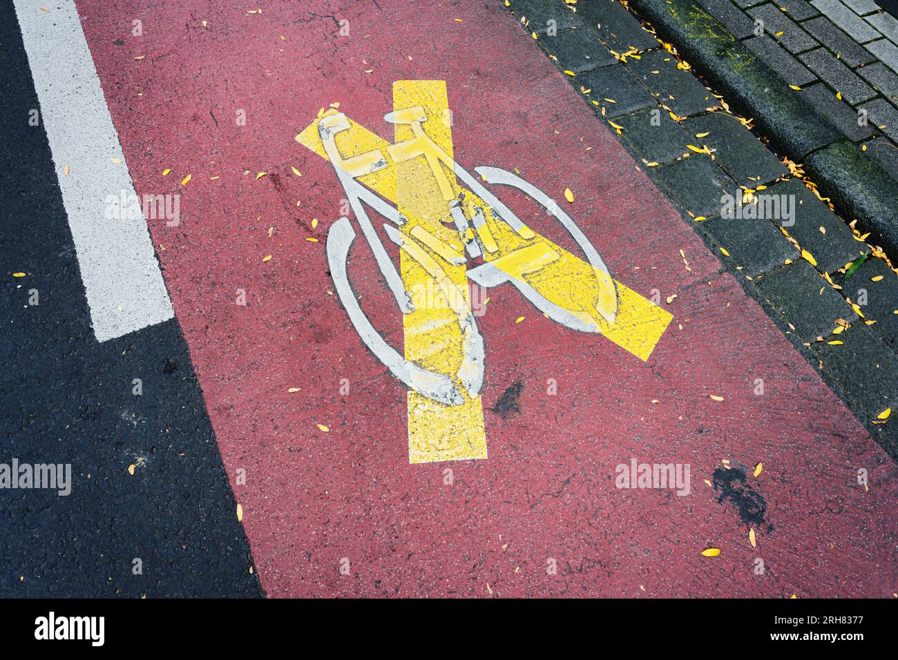 una pista ciclabile segnalata in rosso è stata cancellata con una croce gialla in una città tedesca Foto Stock