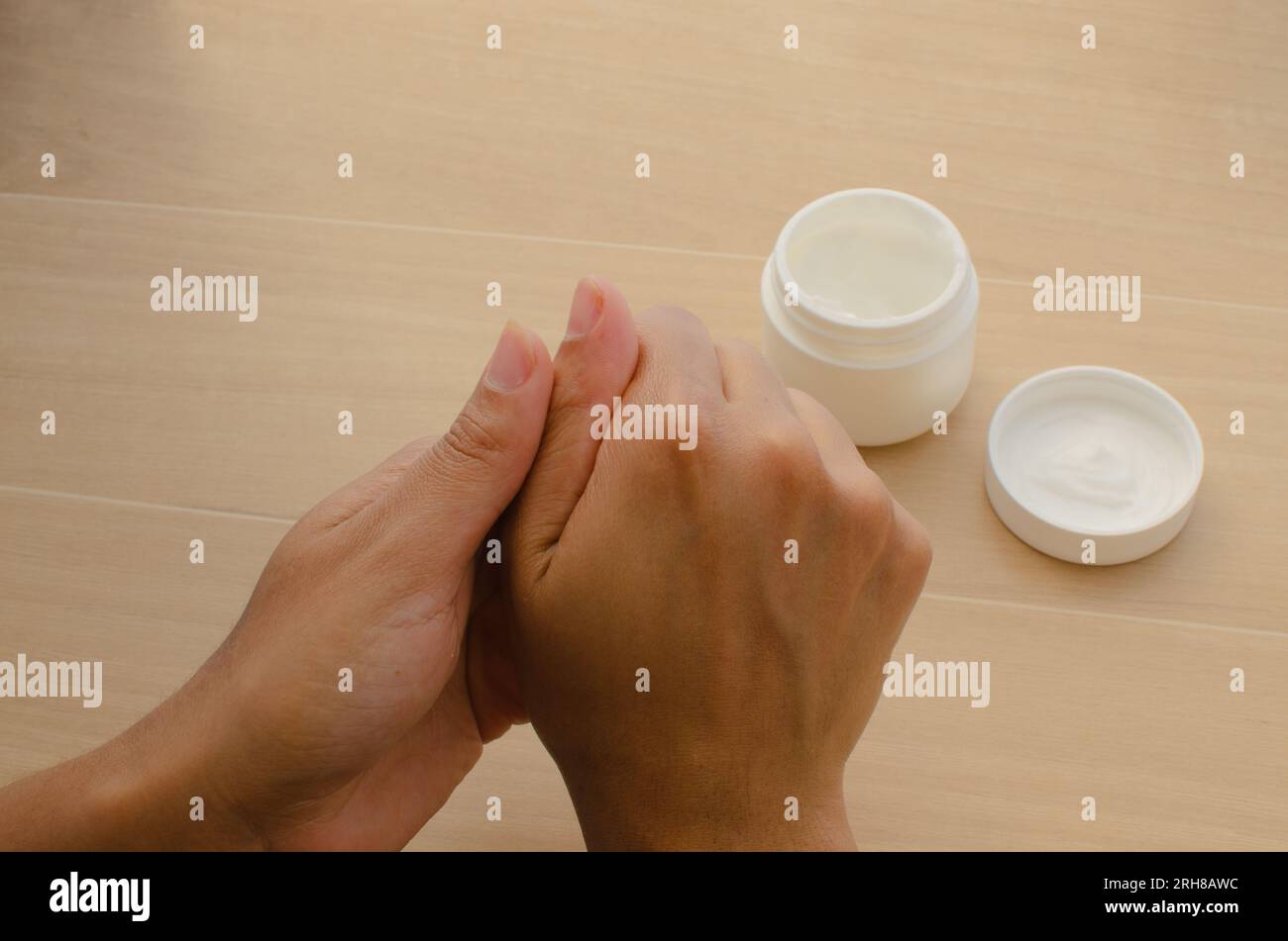 Dettagli per la cura personale: Mani che utilizzano una crema nutriente per favorire l'idratazione della pelle. Foto Stock